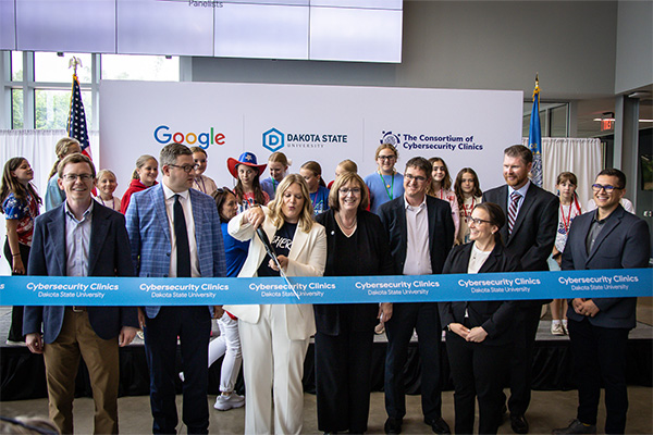 Members of the panel pose for a photo as Dr. Ashley Podhradsky cuts the ribbon.